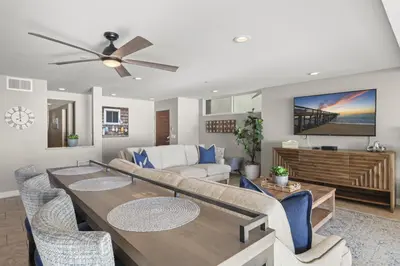 a living room with a dining table and a couch at Hawaiian Style Beachfront on Beach Road in Dana Point
