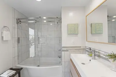a white bathroom with a tub and a shower at Hideaway D Walk to the beach Downtown AC in San Clemente