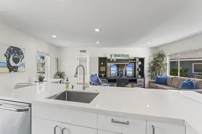 a kitchen with a sink and a living room at Hideaway D Walk to the beach Downtown AC in San Clemente