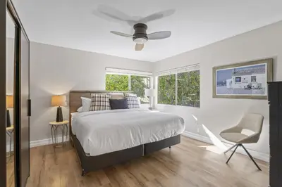 a white bedroom with a bed and a window at Hideaway A Walk to the beach Downtown AC in San Clemente