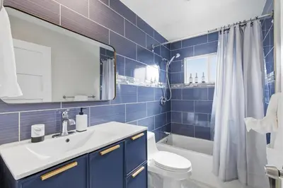 a blue bathroom with a sink and a toilet at New Modern 2BR Home with Movie theater, & Big Yard in La Mesa