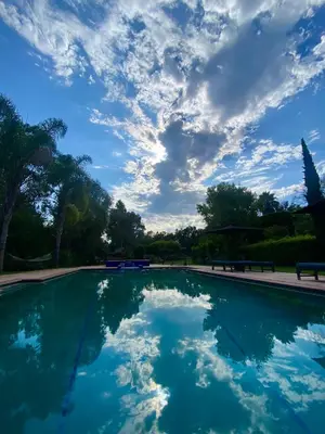 a swimming pool with a cloudy sky in a park at 2 Bedroom Lux Casita with Resort Amenities in Encinitas