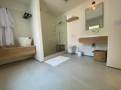 a bathroom with a shower and a sink and a mirror at 2 Bedroom Lux Casita with Resort Amenities in Encinitas