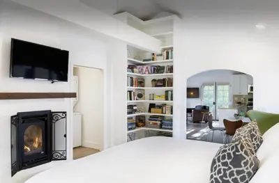 a bedroom with a fireplace and a tv on a wall at 2 Bedroom Lux Casita with Resort Amenities in Encinitas
