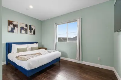 a bedroom with a blue bed and a window at Spacious 3BR Home with Pool in La Mesa