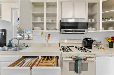 a kitchen with white cabinets and a stove top oven at 3BR Home w/Big Yard, Close to Shops & Attractions in San Diego