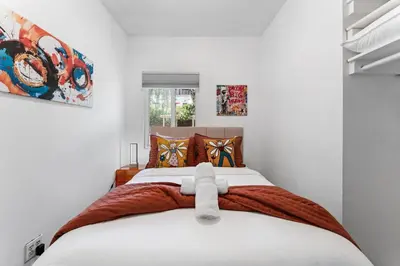 a bedroom with a large white bed with orange pillows at 3BR Home w/Big Yard, Close to Shops & Attractions in San Diego