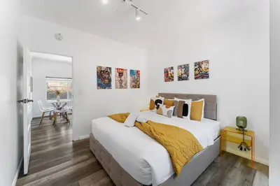 a white bedroom with a large bed and a table at 3BR Home w/Big Yard, Close to Shops & Attractions in San Diego