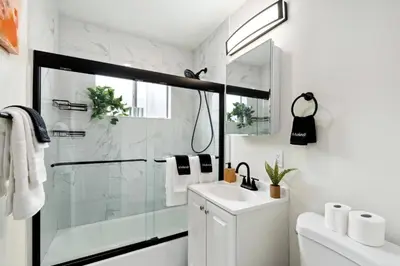 a white bathroom with a shower and a sink at Pacific Beach Paradise-Walk to Beach &Bay in San Diego