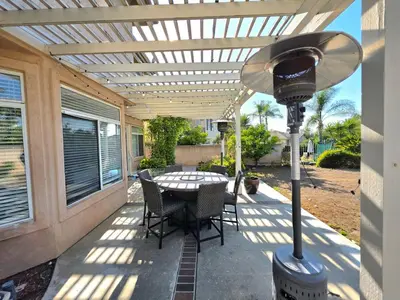 a patio with a table and chairs under a pergola at Modern Residence with Mountain Views in Escondido