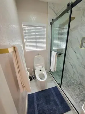 a bathroom with a toilet and a glass shower at Modern Residence with Mountain Views in Escondido