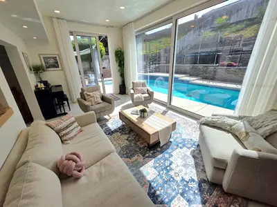 a living room with a couch and a table and a pool at Sunny 5BEDR00MS with Pool, Zip Line, Game Room, Kid's Playhouse in San Diego