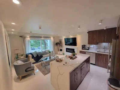 a kitchen and living room with a couch and a table at Newport Beach Lux in Newport Beach