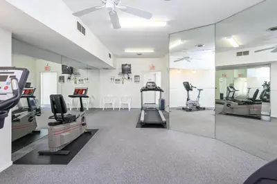 a gym with treadmills and machines in a room at Newport Beach Lux in Newport Beach