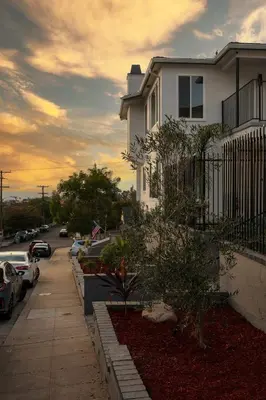 a white house with cars parked in a parking lot at Cozy Studio Near Balboa Park in San Diego