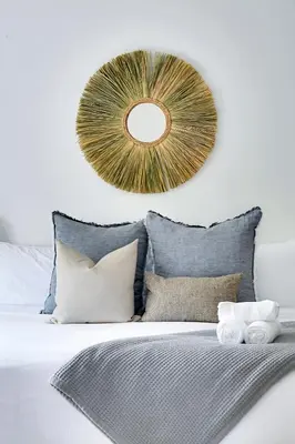a mirror on a wall above a bed with pillows at La Jolla Oasis - Spa, Sauna, Beach, Shops, UCSD in San Diego