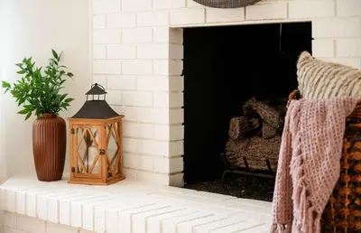 a white brick fireplace with a potted plant and a lantern at La Jolla Oasis - Spa, Sauna, Beach, Shops, UCSD in San Diego