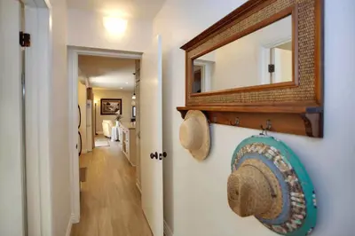 a hallway with a mirror and a hat on a wall at Bayfront 4Br Retreat With Stunning Newport Harbor Views By Beachview Rentals in Newport Beach