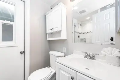 a white bathroom with a toilet and a sink at 4Br Coastal Getaway Between The Bay And The Beach By Beachview Rentals in Newport Beach
