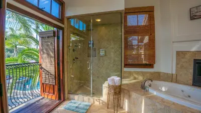 a bathroom with a tub and a glass shower at Oceanside Tropical Resort with HEATED POOL & SPA! in Oceanside