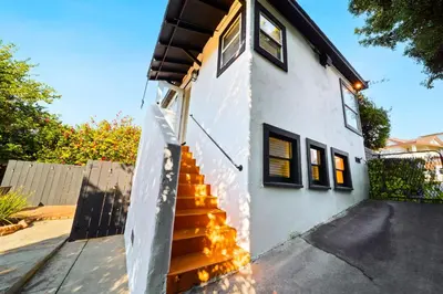 a white house with stairs leading up to it at Little Italy Delight 3 bedroom backyard parking in San Diego