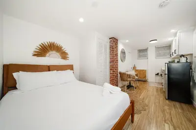 a bedroom with a bed and a kitchen with a refrigerator at Little Italy Delight 3 bedroom backyard parking in San Diego
