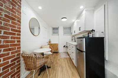 a kitchen with a black refrigerator and a brick wall at Little Italy Delight 3 bedroom backyard parking in San Diego