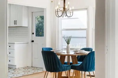 a dining room with a table and blue chairs at Little Italy Delight 3 bedroom backyard parking in San Diego