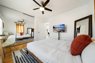 a bedroom with a white bed and a ceiling fan at Little Italy Home with Parking and Backyard in San Diego
