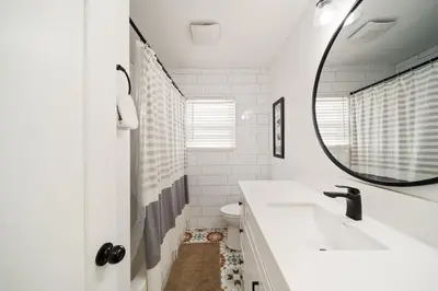 a white bathroom with a sink and a mirror at Little Italy Home with Parking and Backyard in San Diego