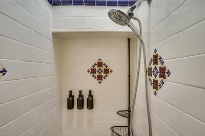 a shower in a bathroom with bottles on the wall at Creative SoCal Escape! Trabuco Canyon Casita