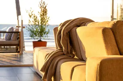 a couch with a blanket on it in a living room at Casa Azul at Mission Beach Oceanfront Getaway in San Diego