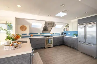 a kitchen with blue and white walls and stainless steel appliances at Casa Azul at Mission Beach Oceanfront Getaway in San Diego