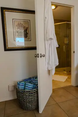 a bathroom with a shower and a basket of towels at 2 Bdr 2 bath luxury home steps away from Mission Beach 5 min from Belmont in San Diego