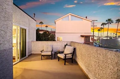 a patio with two chairs and a table on a balcony at Cozy Coastal Townhome in the Heart of Pacific Beach in San Diego