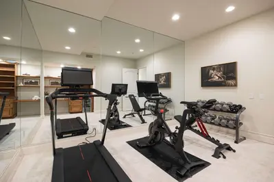 a gym with treadmills and exercise bikes in a room at ResortHome Pickle Ball Pool MovieRoom Gym Sauna Villa in Del Mar