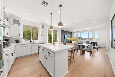 a kitchen and dining room with white cabinets and a table at Marbella Lane - Curated 5BR in Upscale RMV Haven in Ladera Ranch