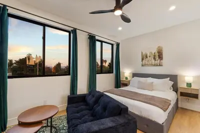 a bedroom with a bed and a couch and windows at Private Studio - Stylish Cozy & Central in San Diego