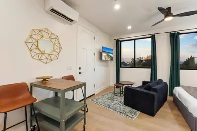 a living room with a bed and a table and chairs at Private Studio - Stylish Cozy & Central in San Diego