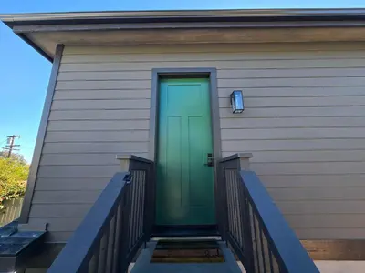 a green door on the side of a house at Private Studio - Stylish Cozy & Central in San Diego