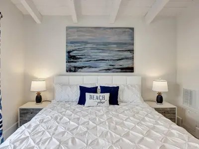 a bedroom with a large white bed with two lamps at Seaglass 222 in San Clemente