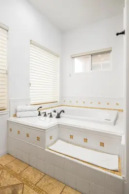 a white bathroom with a tub and a sink at Ocean View 4 Bedroom Home in Carlsbad