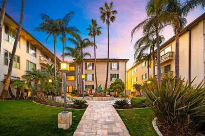 a walkway in front of a building with palm trees at La Jolla Studio - Private Beach in San Diego