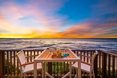 a table and chairs on a deck overlooking the ocean at La Jolla Studio - Private Beach in San Diego