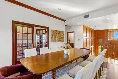 a dining room with a wooden table and white chairs at Indoor Pool & Spa - Gym - Sauna - Pickleball Court in Perris
