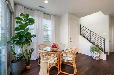 a dining room with a table and chairs and a staircase at Beautiful Spacious Condo in an Excellent Location in Chula Vista