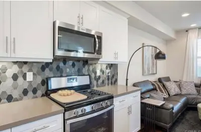 a kitchen with a stove top oven next to a couch at Beautiful Spacious Condo in an Excellent Location in Chula Vista