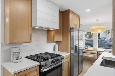 a kitchen with wooden cabinets and a stove top oven at One Block to Beach 4BR Game Room and Parking in San Diego