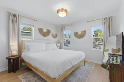 a white bedroom with a bed and two windows at One Block to Beach 4BR Game Room and Parking in San Diego