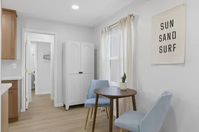 a kitchen with a table and two blue chairs at One Block to Beach 4BR Game Room and Parking in San Diego